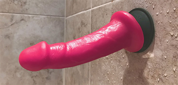 a suction cup dildo stuck to a shower wall