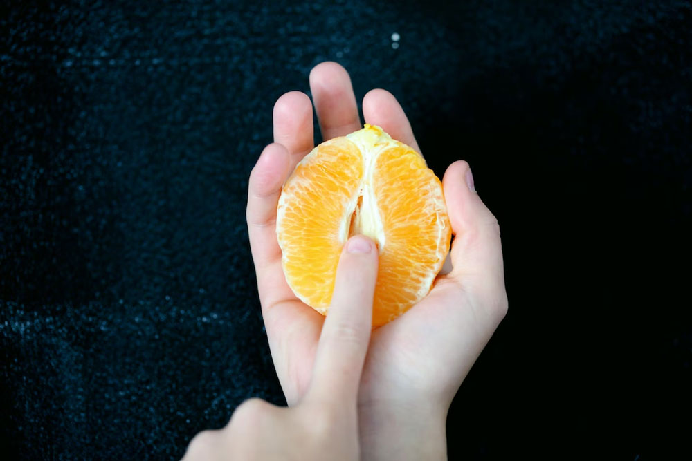 finger squished into an orange
