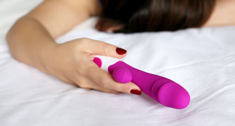 A woman holding a sex toy, exploring the world of personal pleasure
